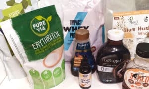 Illustrational image of low-carb pantry essentials showing sweeteners and protein powder in their original packaging.