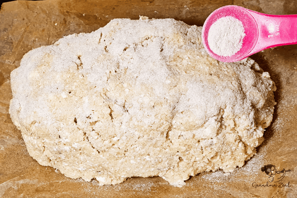 Oval-shaped keto rye bread dough on a parchment-lined baking tray, dusted with potato fibre for a rustic look.