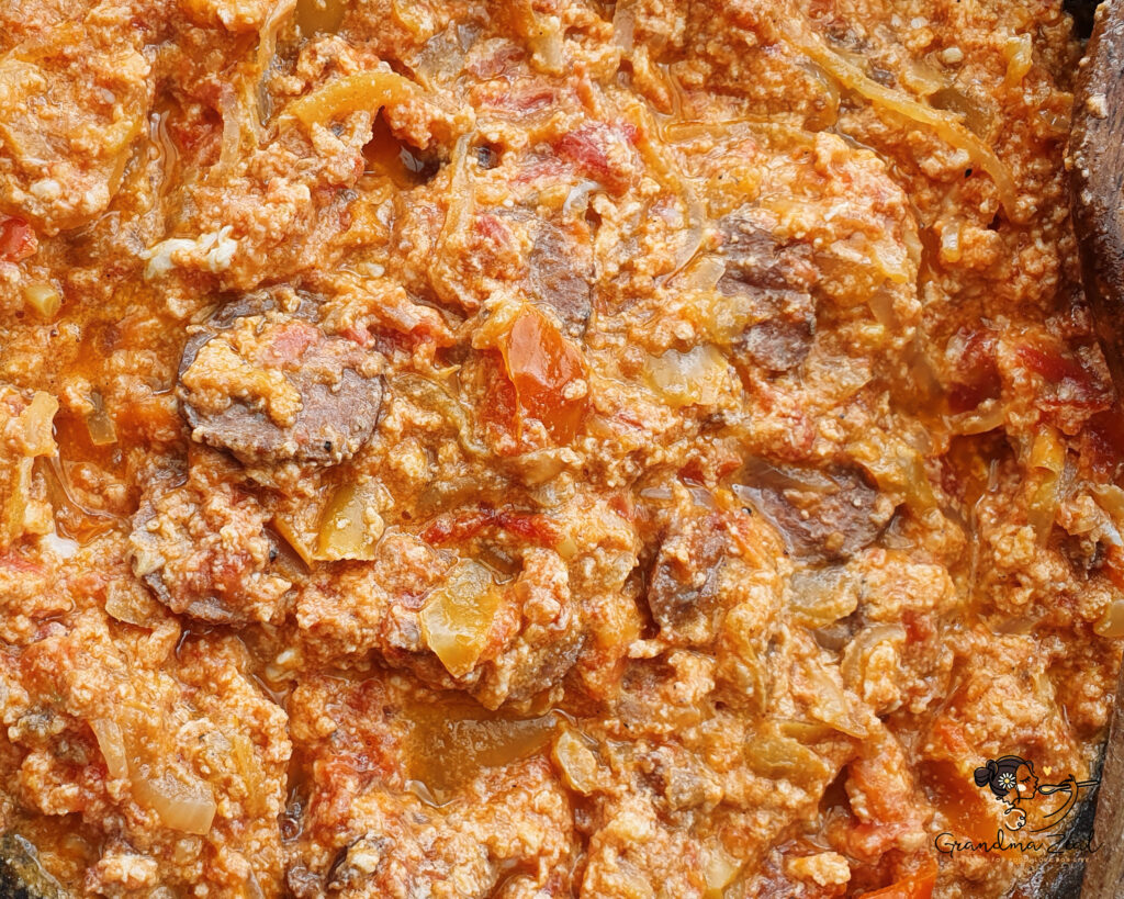 Close-up of Hungarian lecso with scrambled eggs and sliced sausage
