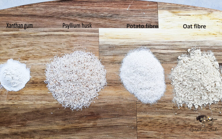 Four different types of dietary fibre ingredients displayed on a wooden chopping board