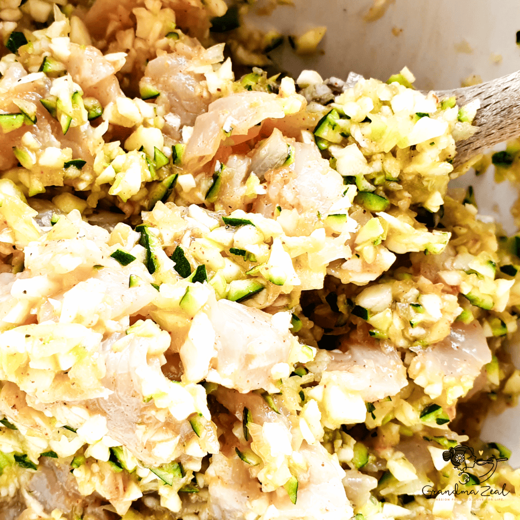 Chicken, onion, courgette, and spices being stir-fried in a skillet at high heat during the first stage of cooking stroganoff.