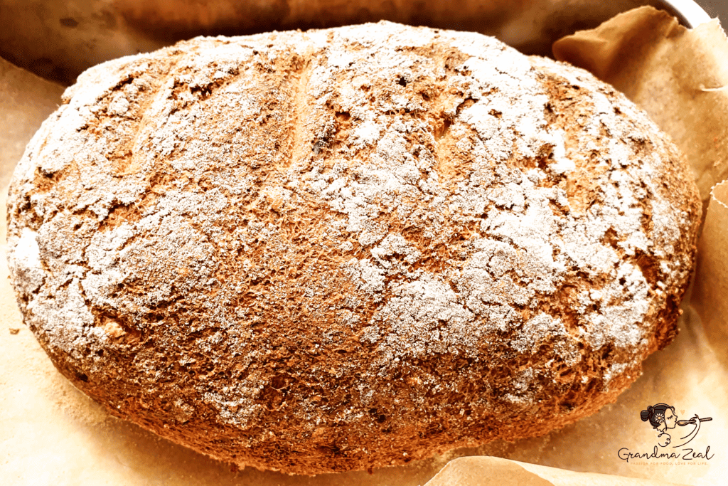 Freshly baked keto rye bread still in the baking tray, golden brown with a rustic crust.