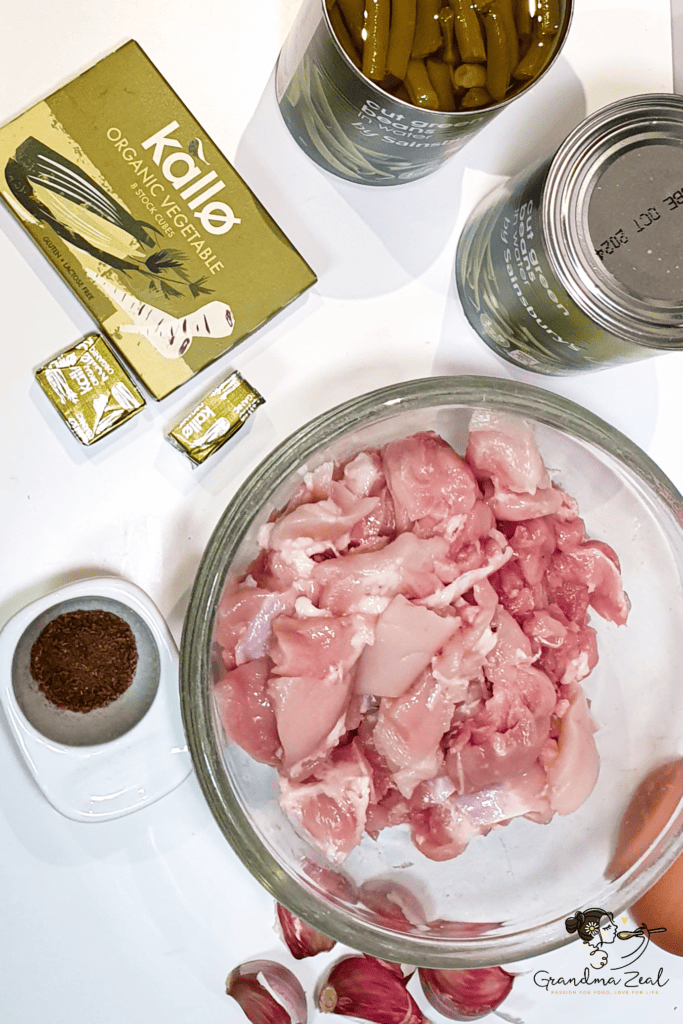 op-down view of ingredients for garlic chicken with green beans, laid out on a kitchen surface.