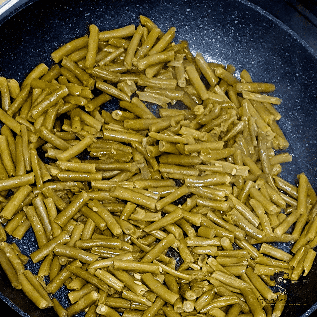 Cut green beans frying in a pan, lightly sautéed