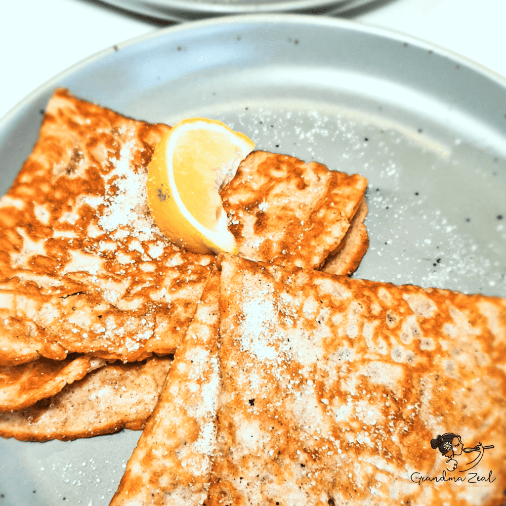 Two folded oat bran pancakes in a rectangle shape, served with monk fruit sweetener and lemon – a British classic