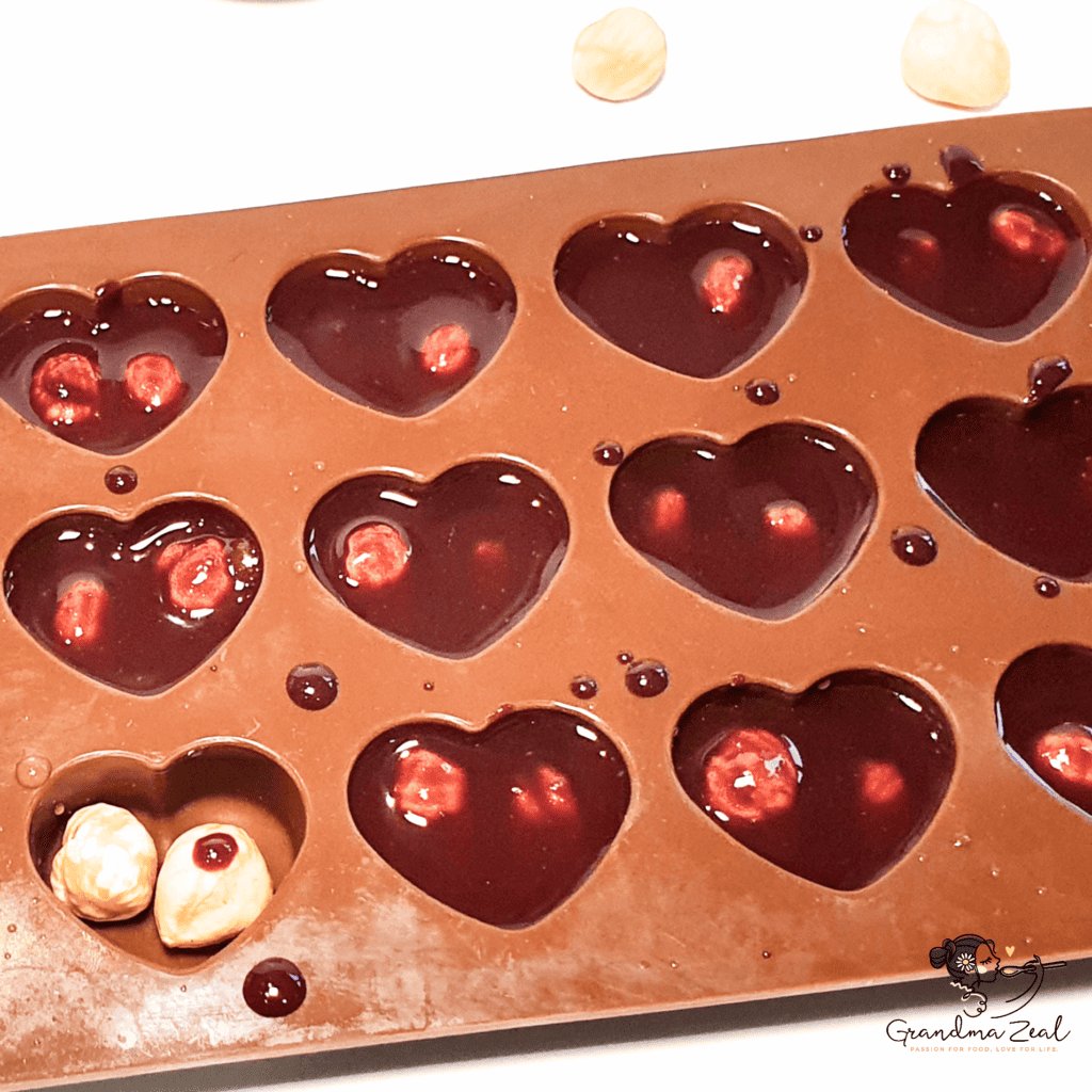 Silicone mould filled with homemade chocolate and hazelnuts shaped into hearts