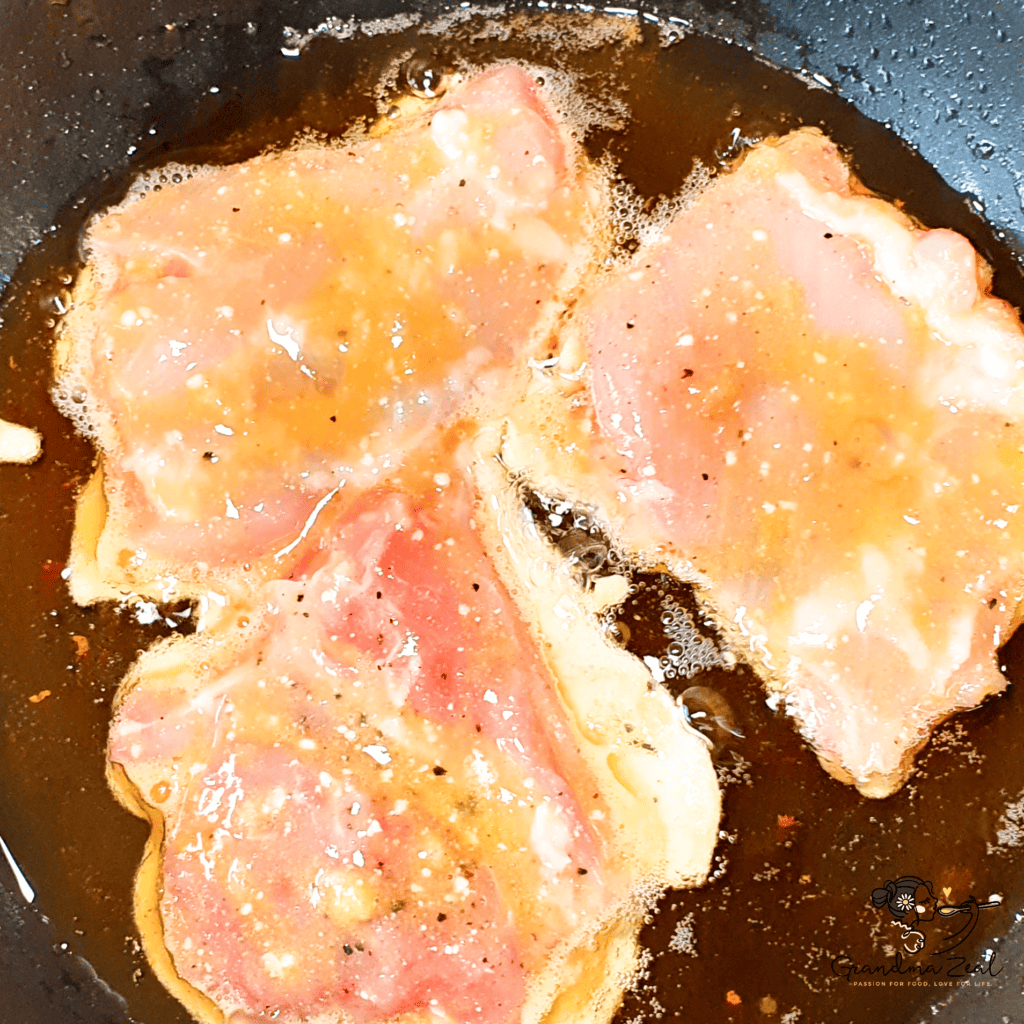 Chicken pieces frying in a pan until golden and crispy
