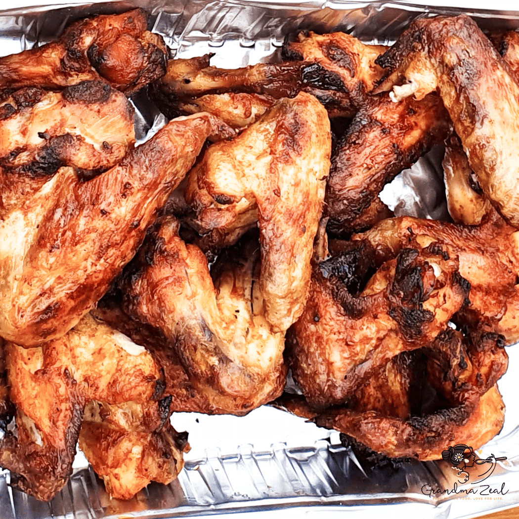 UNFORGETTABLE CHICKEN WINGS – CRISPY, JUICY & ADDICTIVE Golden roast chicken wings in a foil tray, fresh from the oven with crispy edges., set as feature picture