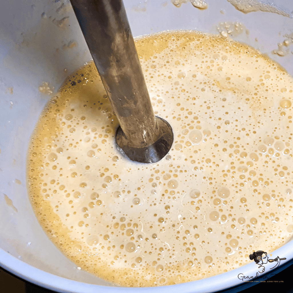 Whisking eggs with mascarpone and quark in a mixing bowl to prepare the base for keto rye bread dough.