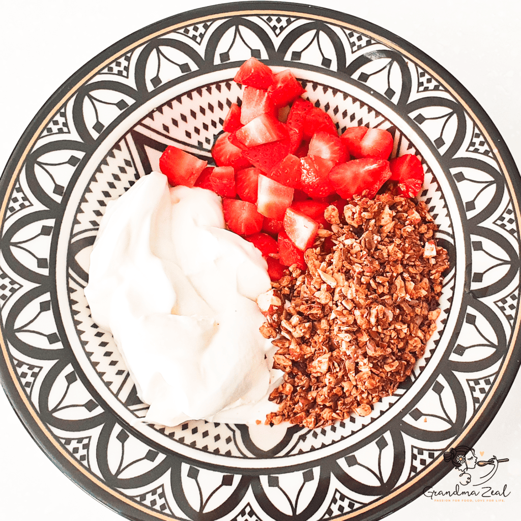 Low-carb granola with yoghurt and chopped strawberries on a plate