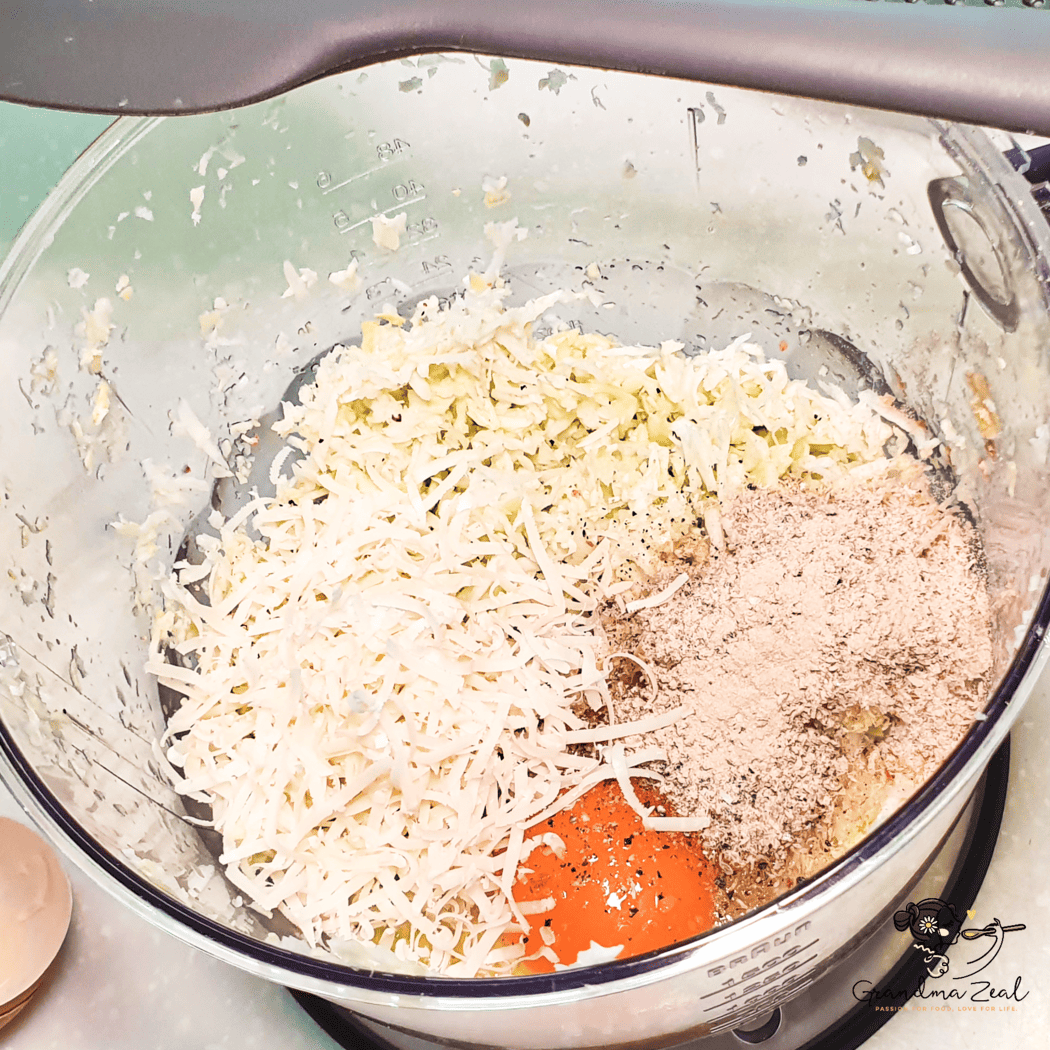 Chopped cabbage in a bowl with added eggs, cheese, and seasoning for veggie hash browns