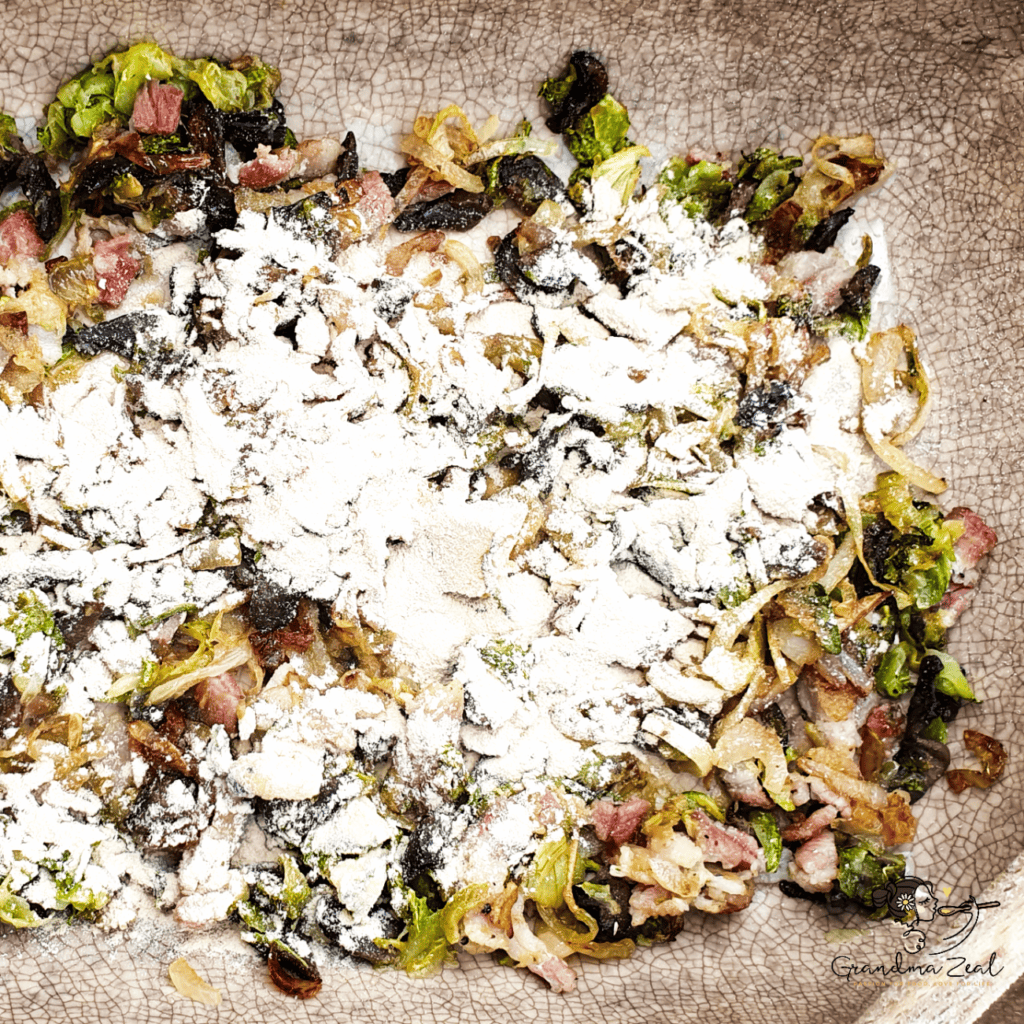 Fried bacon, courgette, mushrooms, and onion mixed with potato fibre in a baking tray for crustless quiche.