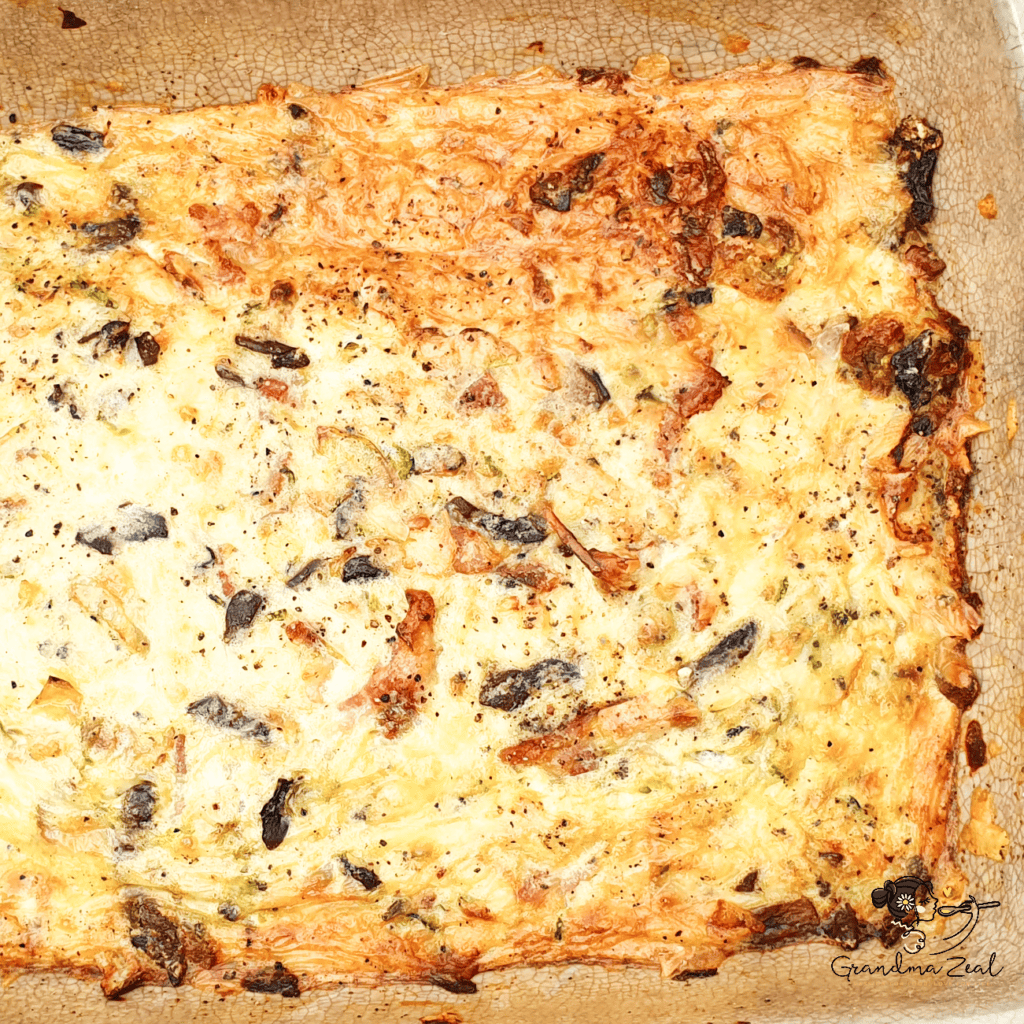 
Golden baked crustless quiche with vegetables and bacon, fresh out of the oven in a rectangular baking