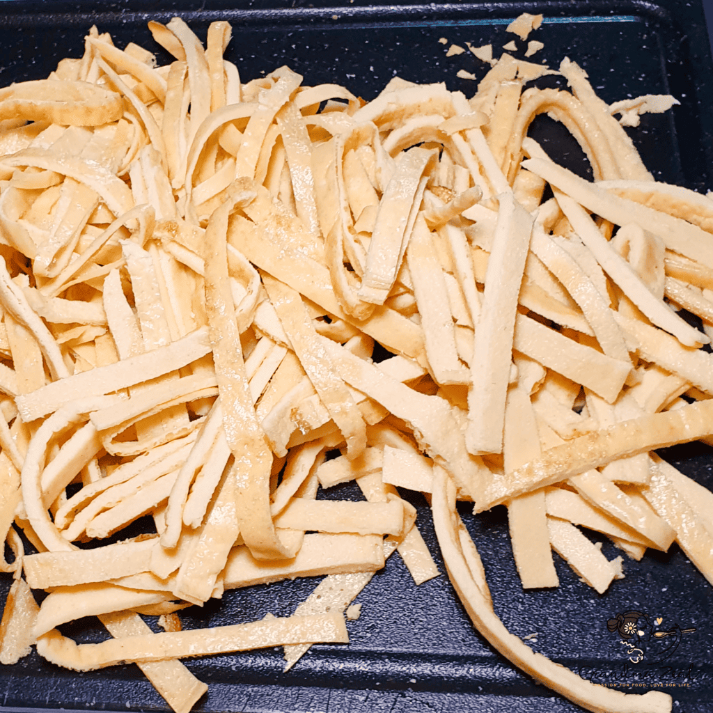 EASY HOMEMADE LOW-CARB TAGLIATELLE WITH QUARK CHEESE AND BACON Home made low-carb tagliatelle pasta, sliced on the chopping board