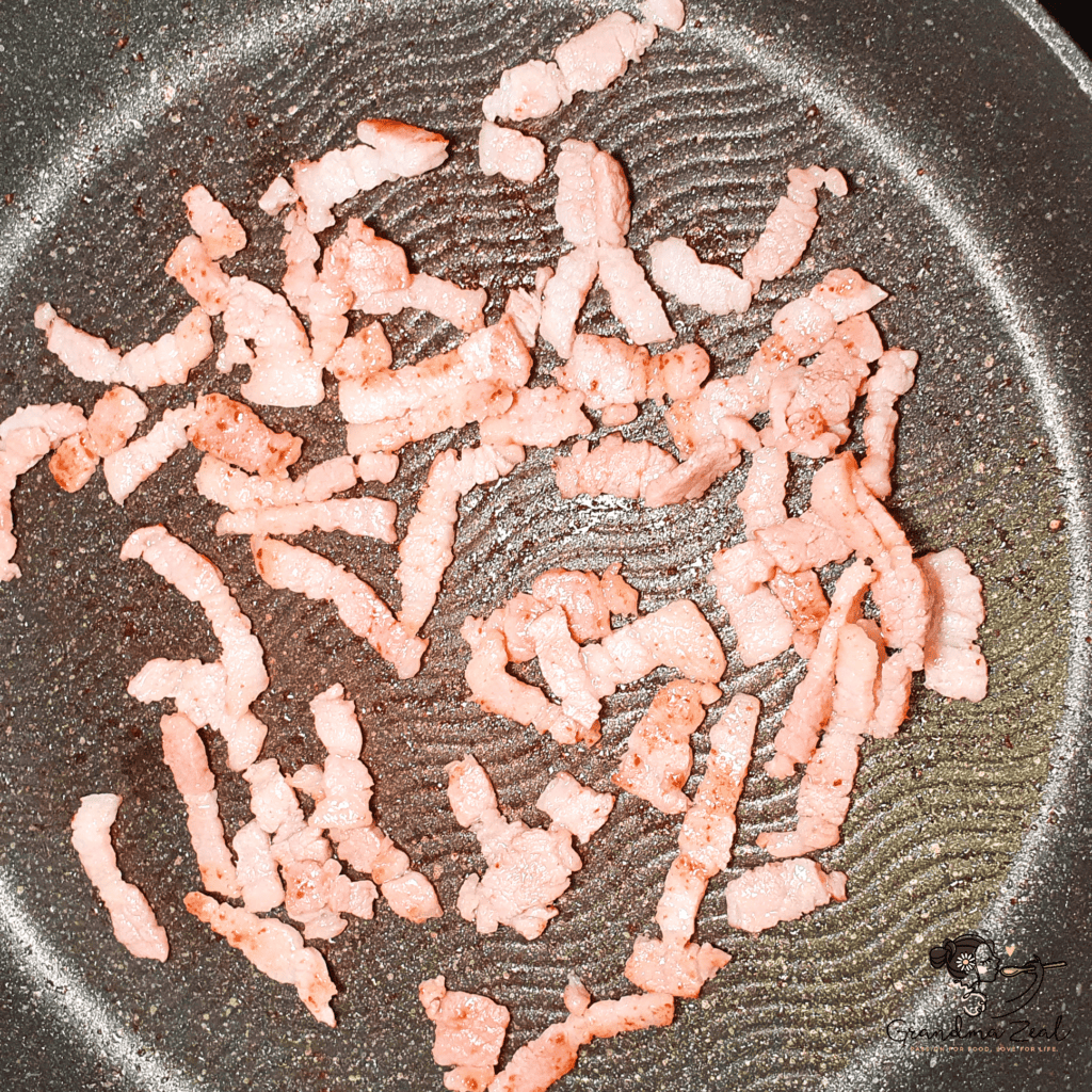 EASY HOMEMADE LOW-CARB TAGLIATELLE WITH QUARK CHEESE AND BACON Fried bacon in the frying pan, ready to toss over the tagliatelle