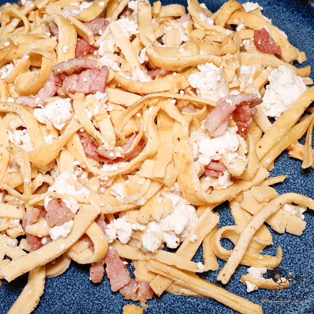 EASY HOMEMADE LOW-CARB TAGLIATELLE WITH QUARK CHEESE AND BACON A portion of low-carb high-fibre tagliatelle with quark cheese and bacon on the plate ready to serve.