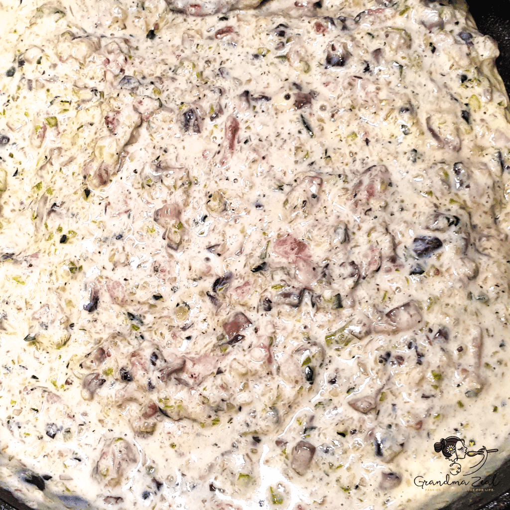 Creamy low-carb carbonara sauce with melted cheese, bacon, and vegetables in a pan, ready to mix with pasta.