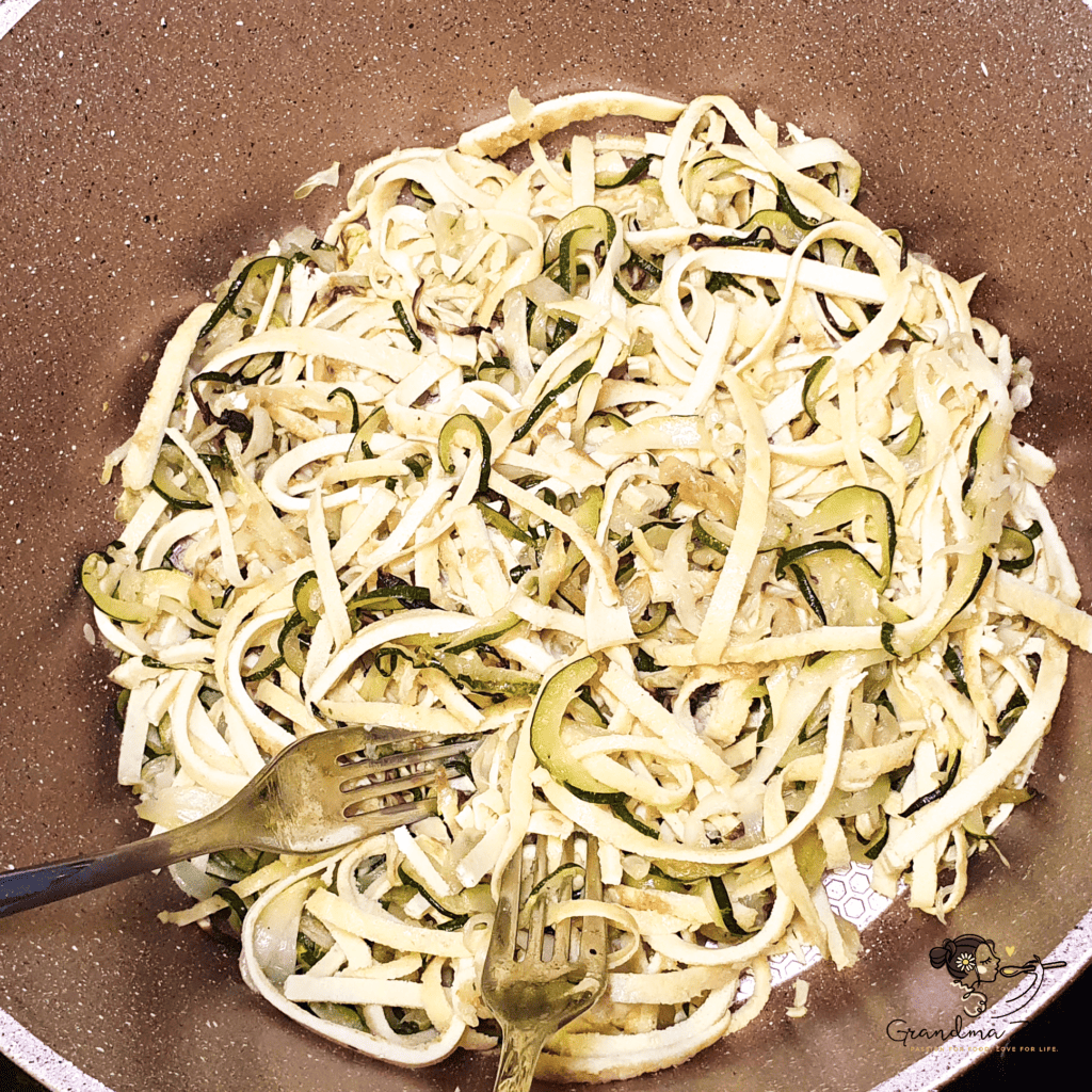 Combined zoodles and high fibre pasta  in a large bowl, ready to be plated and topped with creamy carbonara sauce.