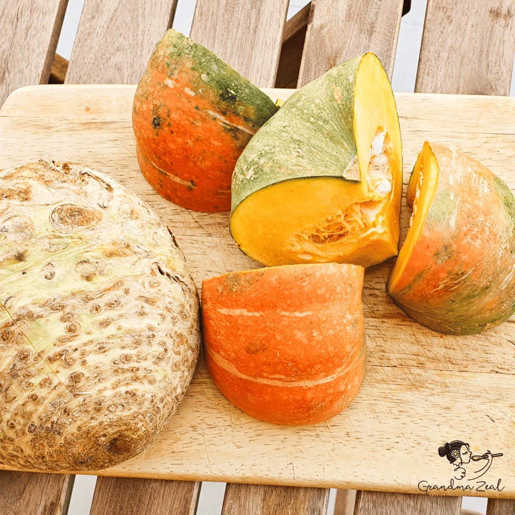 Quartered squash and peeled celery root on a chopping board, ready for roasting.