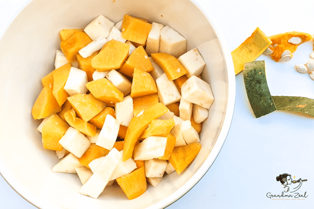 Cubed squash and root vegetables in a bowl, ready to be seasoned for roasting.