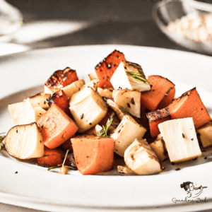 A plate of roasted root vegetables with squash, served as a colorful and healthy side dish.