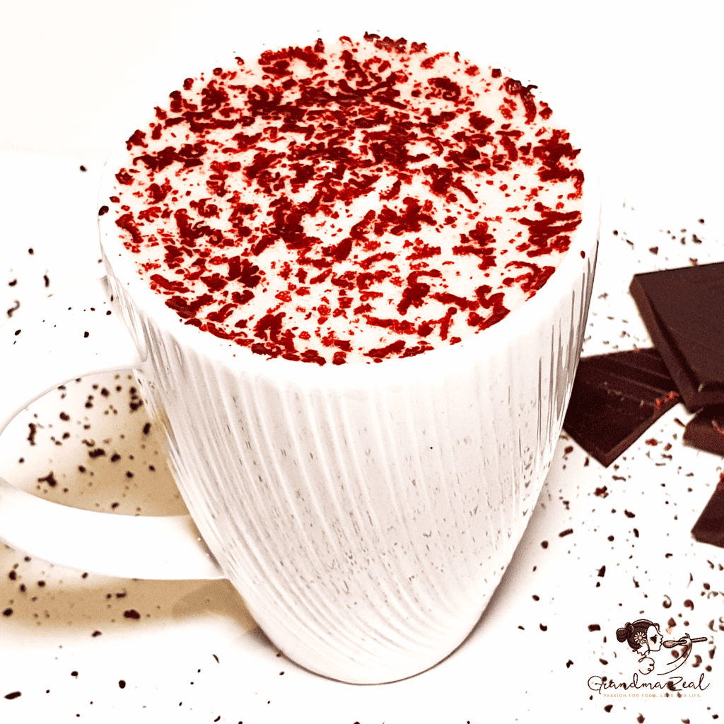 Hot chocolate in a white mug topped with froth and grated chocolate