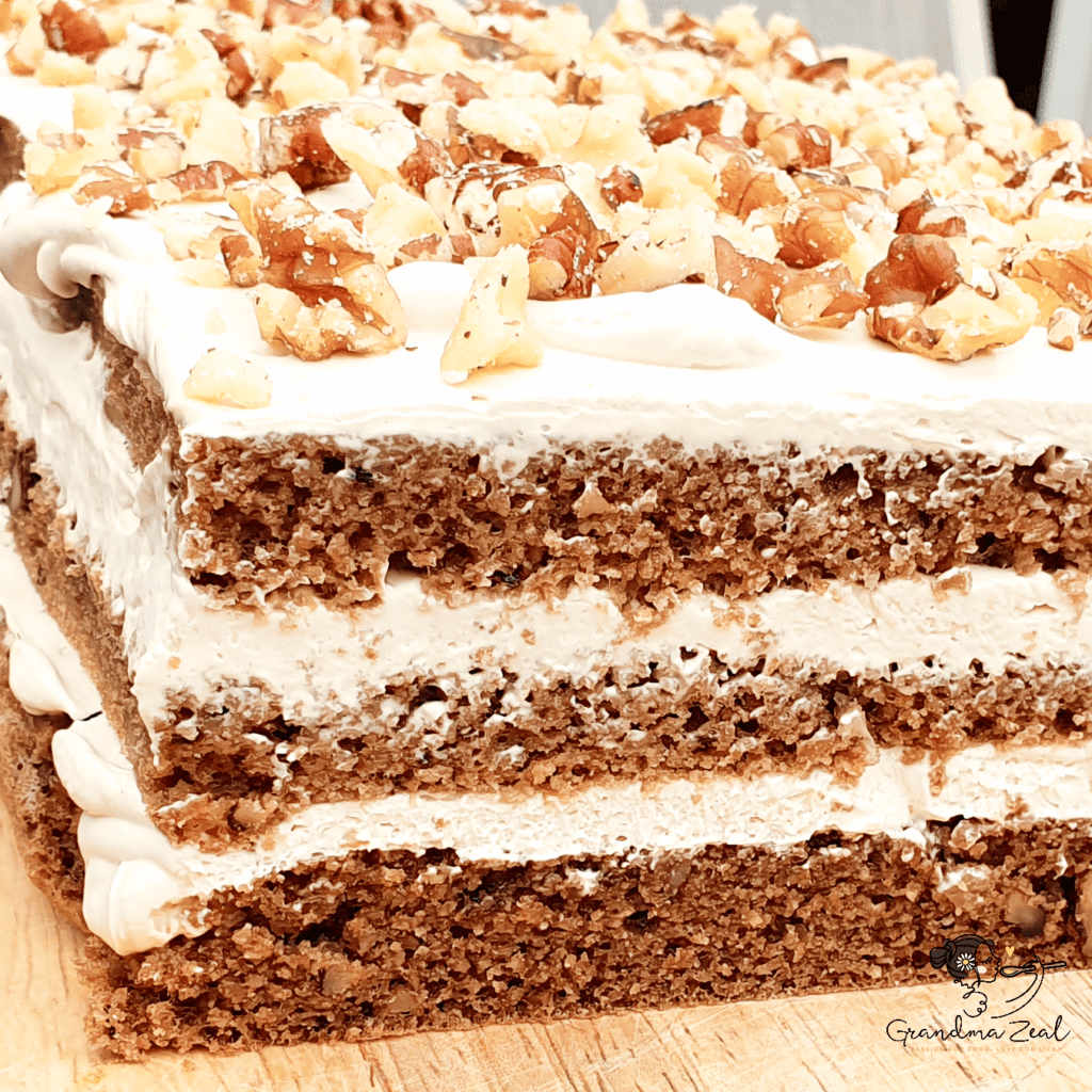 Low-carb coffee walnut cake topped with creamy frosting and chopped walnuts
