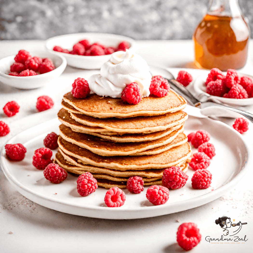 Stack of oat bran pancakes with squirted cream and raspberries, viewed from the side, syrup and bowl of raspberries in the background