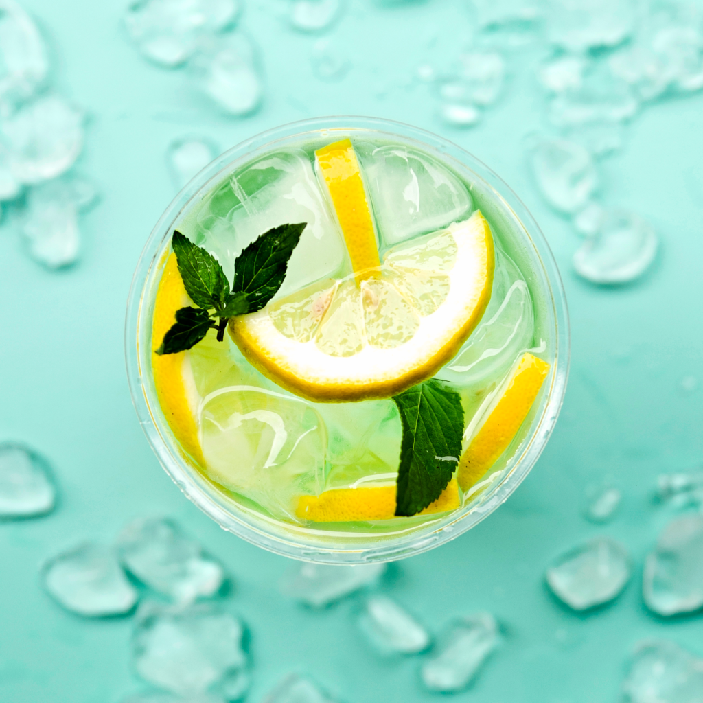 7 AMAZING HEALTH BENEFITS OF DRINKING WATER Glass of water with ice, lemon slices, and mint leaves — illustrating the benefits of drinking water