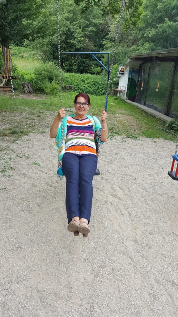 Helena swinging outdoors with joy; an image symbolising freedom and fitness in midlife.