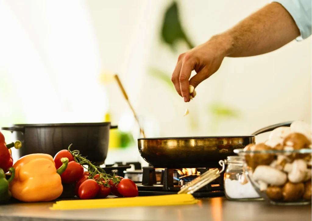 Hand seasoning a dish with fresh vegetables; explore simple, flavourful recipes on GrandmaZeal