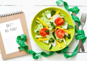 illustration feature picture showing bowl of salad a tape measure and a note block with text ditch the diet