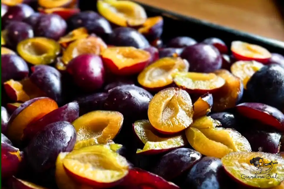 Deep baking tray filled with ripe halved plums prepared for making sugar-free plum butter
