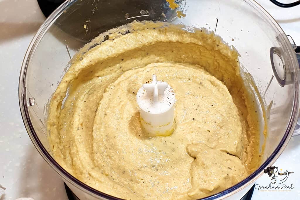 Smooth blended lentil humus in a food processor bowl, showing the creamy texture of the chickpea-free recipe.