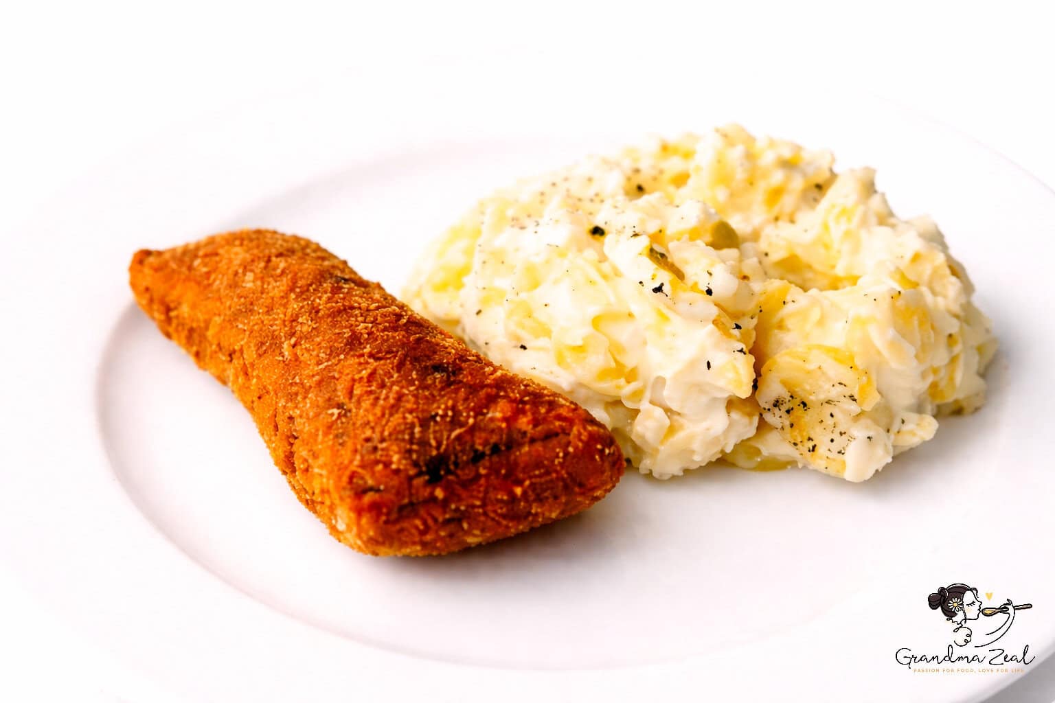 Plate of traditional potato salad served with crispy fried carp