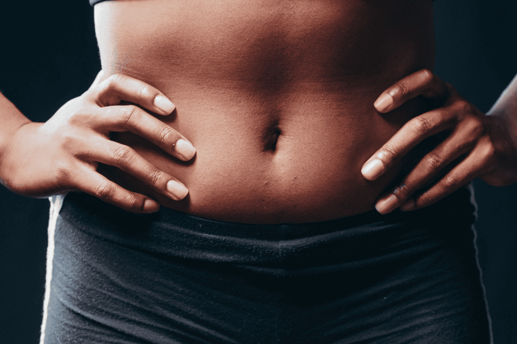 Close-up of a person’s abdominal and core area in activewear, illustrating core exercises.